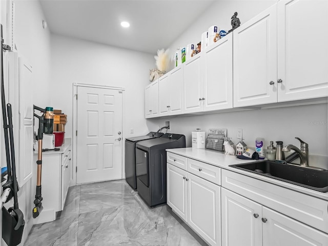 laundry area featuring recessed lighting, marble finish floor, a sink, cabinet space, and washing machine and dryer