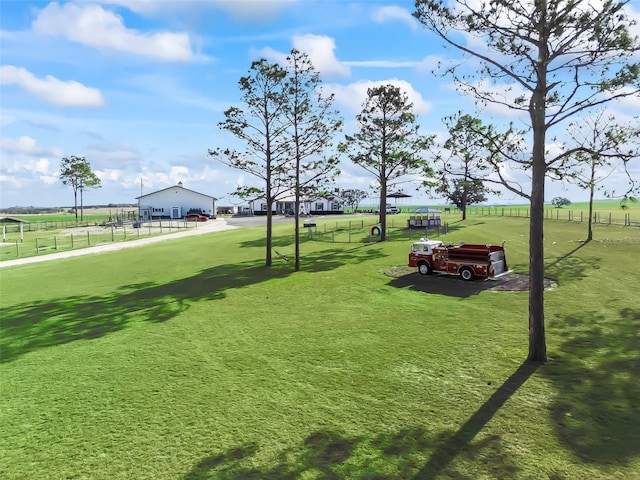 view of community featuring fence and a lawn