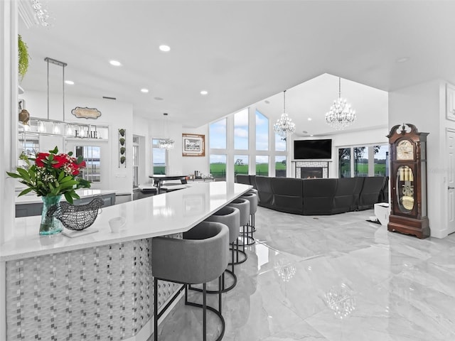 kitchen featuring marble finish floor, a healthy amount of sunlight, and a chandelier