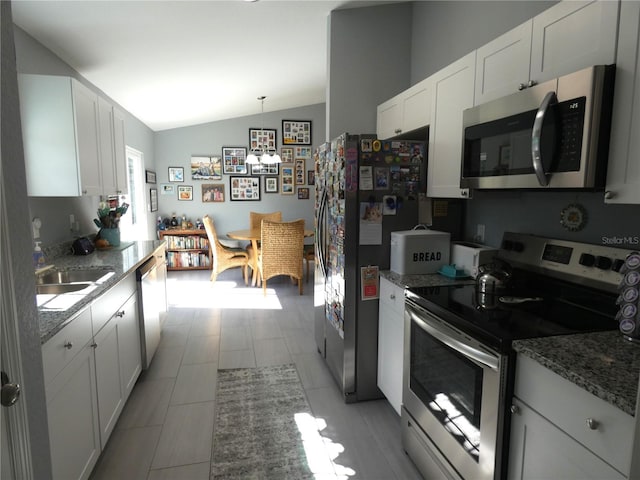 kitchen with white cabinetry, pendant lighting, vaulted ceiling, and appliances with stainless steel finishes