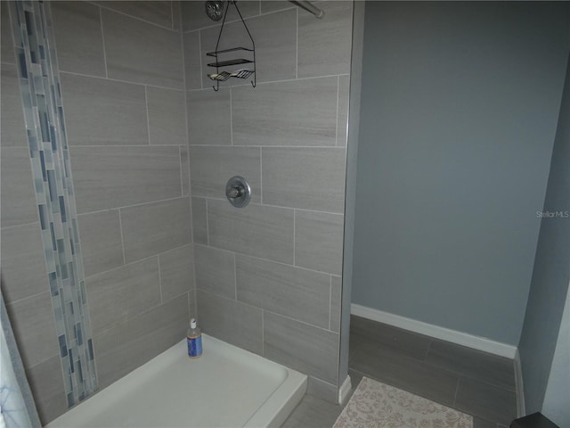 bathroom with a tile shower and tile patterned floors