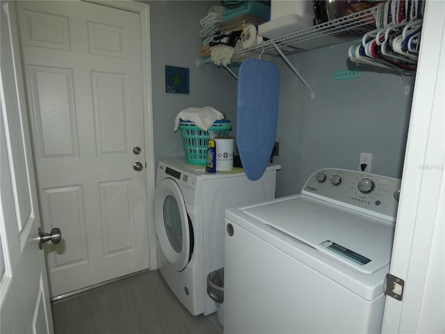 washroom with washer and dryer and light hardwood / wood-style flooring