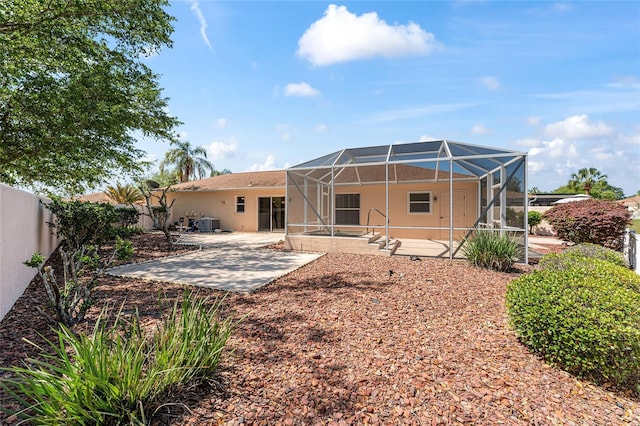 rear view of property featuring a patio area, a fenced backyard, and a lanai