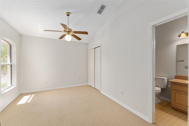 bedroom featuring a textured ceiling, baseboards, light carpet, and visible vents