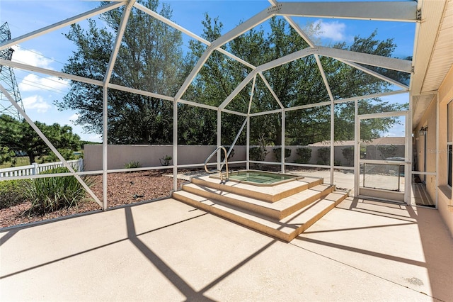 view of patio / terrace featuring an outdoor hot tub, a fenced backyard, and a lanai