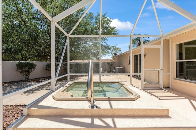 view of swimming pool with fence, a patio area, an in ground hot tub, and a lanai