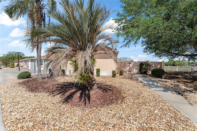 view of side of property with stucco siding, fence, and a gate