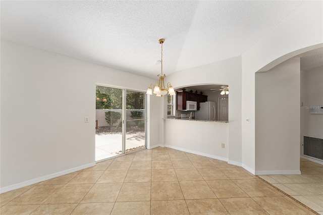 unfurnished room with light tile patterned floors, ceiling fan with notable chandelier, arched walkways, and a textured ceiling