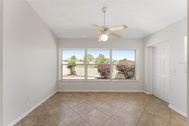 spare room with light tile patterned floors, baseboards, and ceiling fan