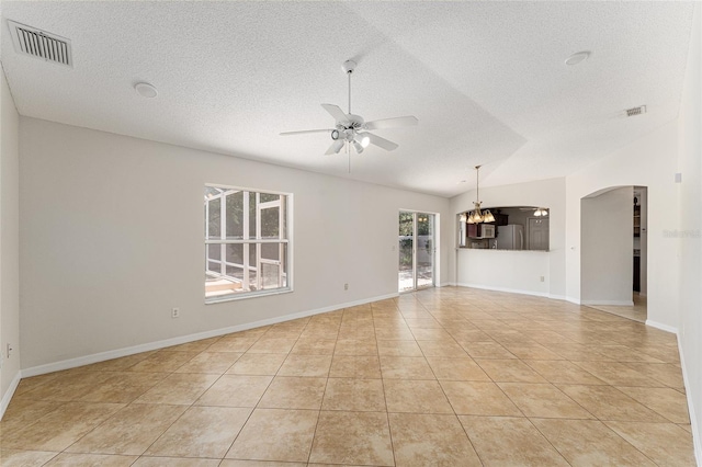 unfurnished living room featuring ceiling fan with notable chandelier, light tile patterned floors, arched walkways, visible vents, and lofted ceiling