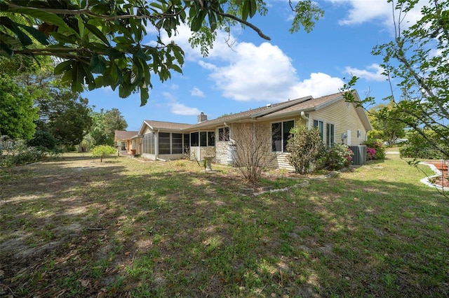 8450 SW 115th Street Rd, Ocala, FL 34481 - back of house with a lawn, a chimney, and a sunroom