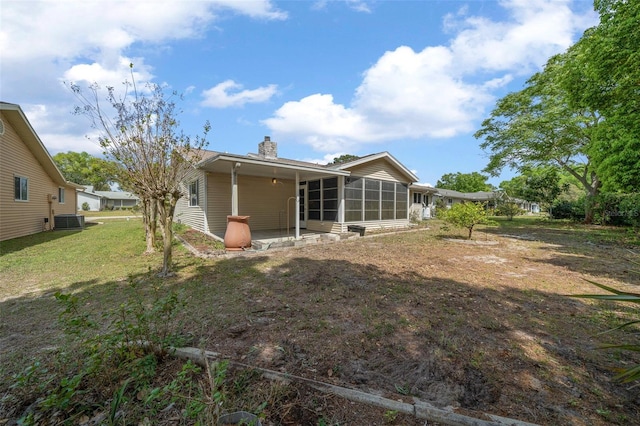 8450 SW 115th Street Rd, Ocala, FL 34481 - back of house featuring a lawn, a chimney, a sunroom, and central AC