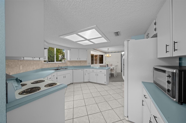 8450 SW 115th Street Rd, Ocala, FL 34481 - kitchen featuring white appliances, a sink, visible vents, white cabinets, and a peninsula