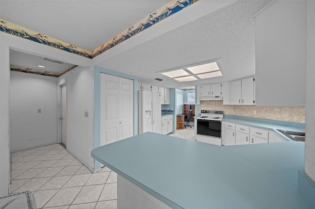 8450 SW 115th Street Rd, Ocala, FL 34481 - kitchen with a textured ceiling, white cabinets, a peninsula, white appliances, and under cabinet range hood