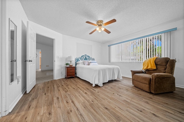 8450 SW 115th Street Rd, Ocala, FL 34481 - bedroom featuring a textured ceiling, light wood-style floors, baseboards, and a ceiling fan