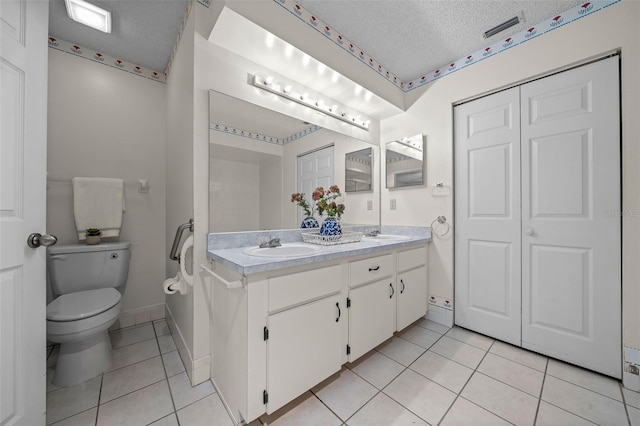 8450 SW 115th Street Rd, Ocala, FL 34481 - bathroom with a textured ceiling, double vanity, toilet, a sink, and tile patterned flooring