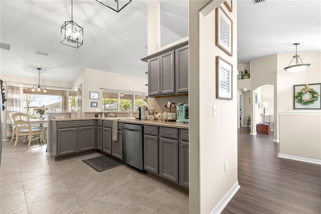 kitchen featuring pendant lighting, gray cabinetry, a chandelier, stainless steel dishwasher, and kitchen peninsula