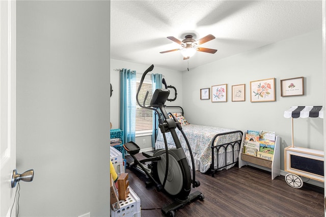 workout area featuring dark hardwood / wood-style flooring, a textured ceiling, and ceiling fan