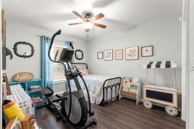 bedroom with ceiling fan, dark hardwood / wood-style floors, and a textured ceiling