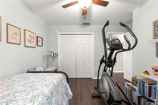 bedroom featuring a closet, dark hardwood / wood-style floors, a textured ceiling, and ceiling fan