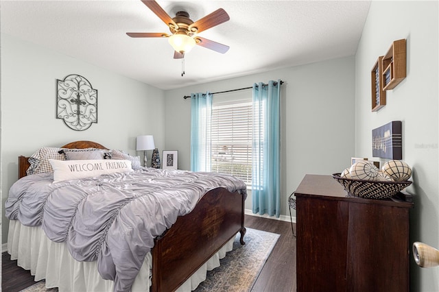 bedroom with ceiling fan, dark hardwood / wood-style floors, and a textured ceiling