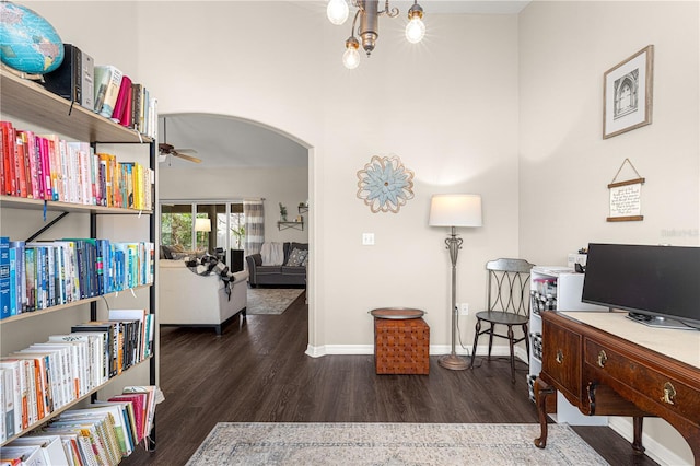 office space featuring dark hardwood / wood-style floors and ceiling fan with notable chandelier