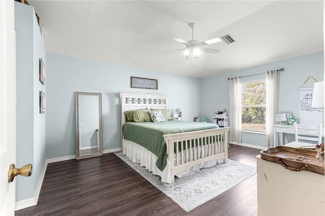 bedroom with a textured ceiling, dark wood-type flooring, and ceiling fan