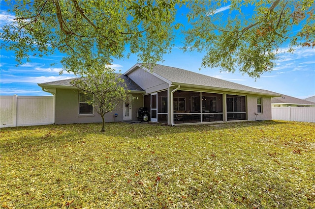 back of property featuring a sunroom and a lawn