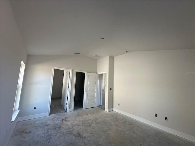 unfurnished bedroom featuring lofted ceiling and concrete flooring