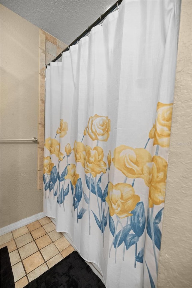 bathroom featuring tile patterned flooring and a textured ceiling