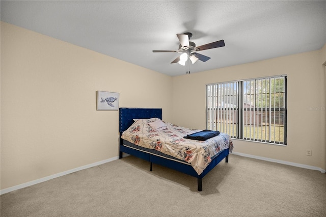 carpeted bedroom with a textured ceiling and ceiling fan