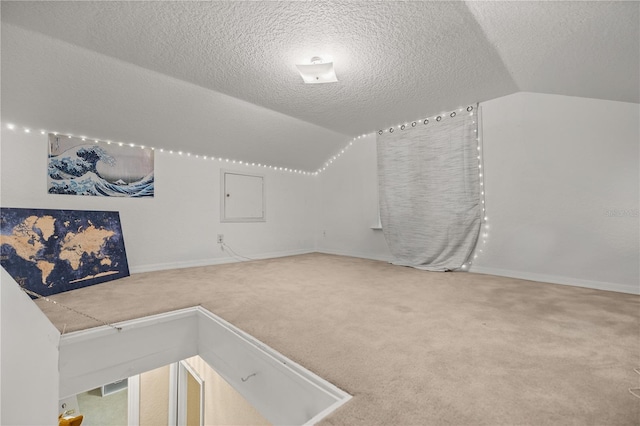 bonus room featuring vaulted ceiling, carpet, and a textured ceiling