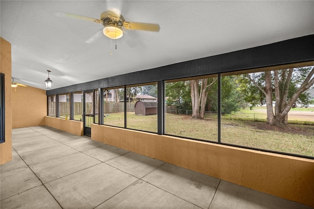 unfurnished sunroom with ceiling fan