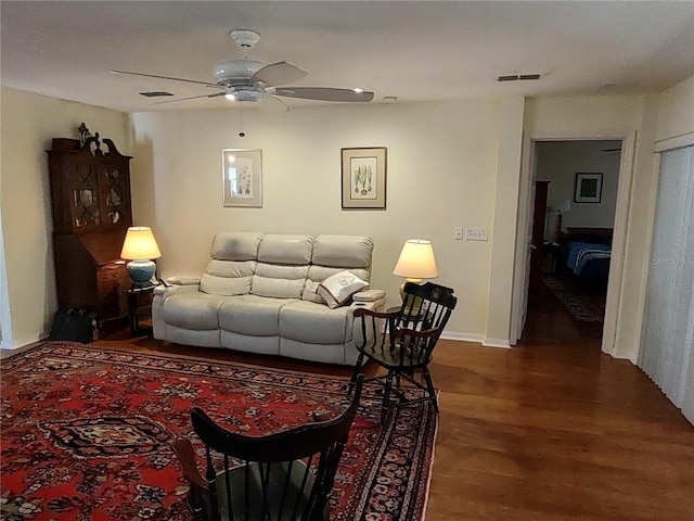 living room with ceiling fan and dark hardwood / wood-style flooring