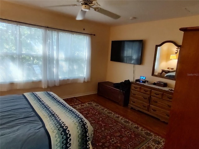 bedroom with multiple windows, wood-type flooring, and ceiling fan