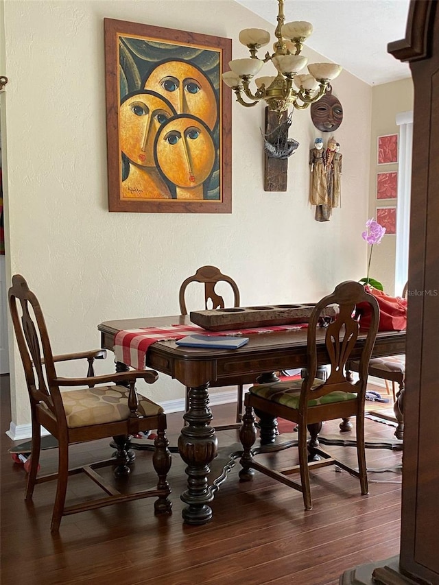 dining room featuring a chandelier, wood finished floors, and baseboards