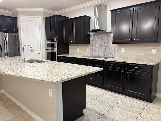 kitchen with sink, ornamental molding, a kitchen island with sink, stainless steel appliances, and wall chimney exhaust hood