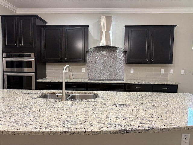 kitchen featuring sink, wall chimney exhaust hood, black electric stovetop, ornamental molding, and stainless steel double oven