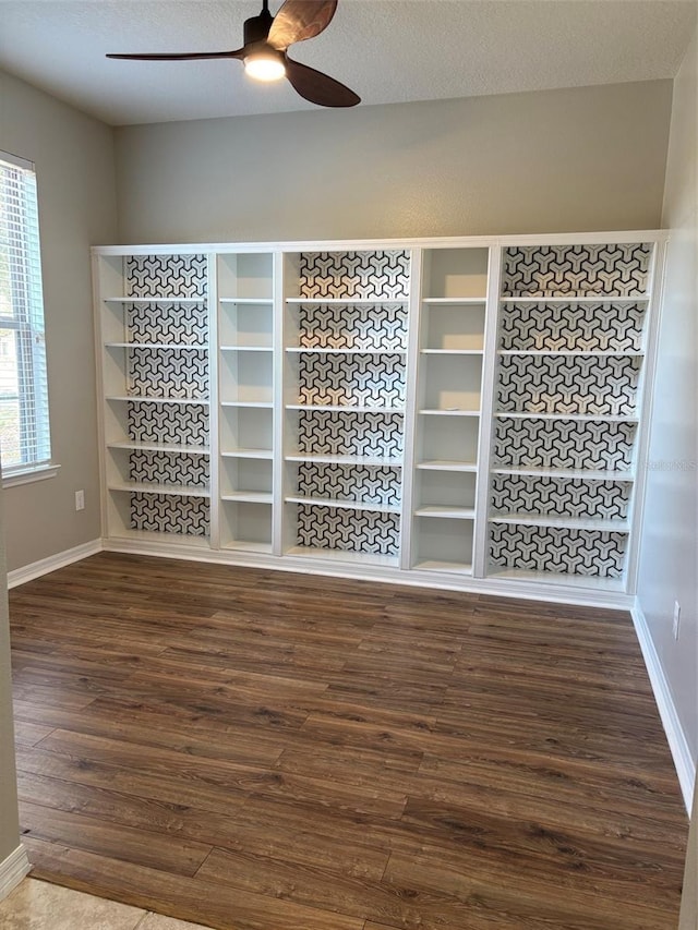 empty room with a textured ceiling, wood-type flooring, and ceiling fan