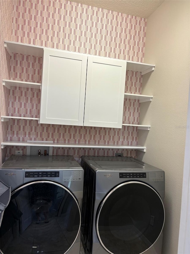 washroom featuring washer and clothes dryer and cabinets