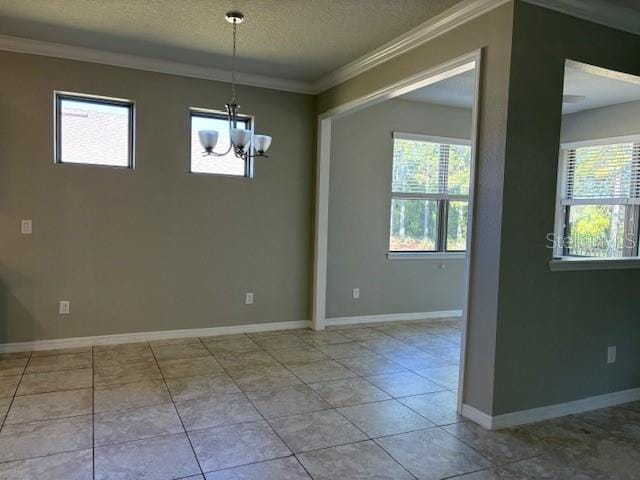 tiled empty room featuring an inviting chandelier, ornamental molding, and a textured ceiling