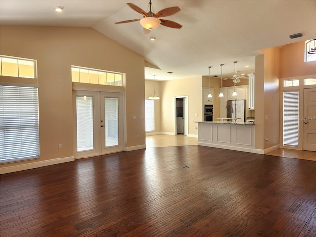 unfurnished living room featuring french doors, ceiling fan, dark hardwood / wood-style flooring, and high vaulted ceiling