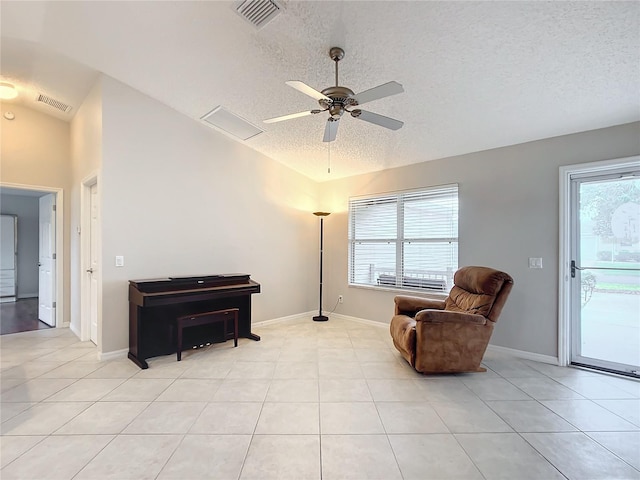 sitting room featuring light tile patterned flooring, ceiling fan, vaulted ceiling, and a textured ceiling