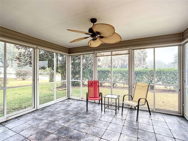 unfurnished sunroom with ceiling fan