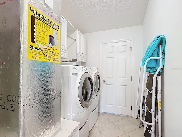 washroom with cabinets, independent washer and dryer, a textured ceiling, and light tile patterned floors