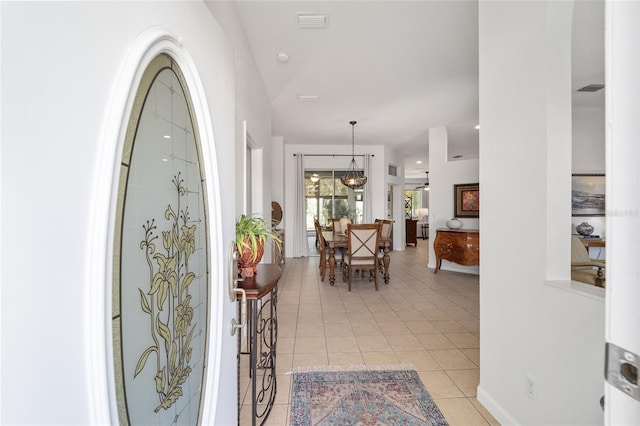 entryway featuring a notable chandelier and light tile patterned floors