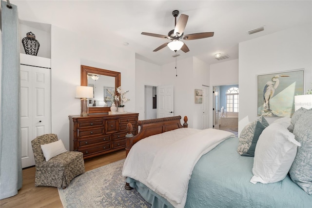 bedroom with vaulted ceiling, ceiling fan, and light hardwood / wood-style flooring