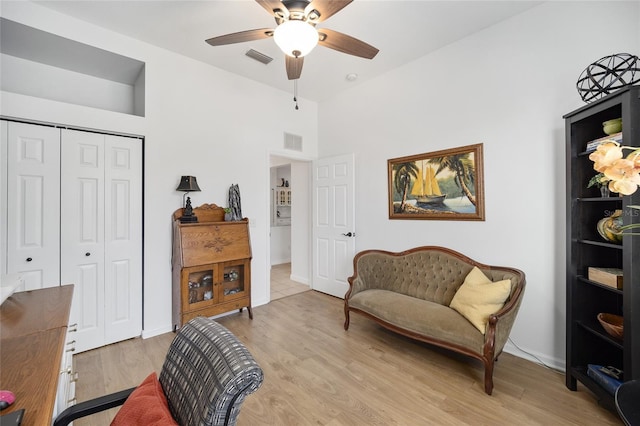 sitting room with ceiling fan, lofted ceiling, and light wood-type flooring