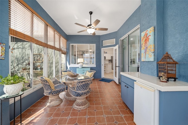 sunroom / solarium featuring ceiling fan