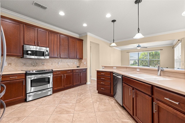 kitchen featuring sink, hanging light fixtures, ornamental molding, light tile patterned floors, and stainless steel appliances